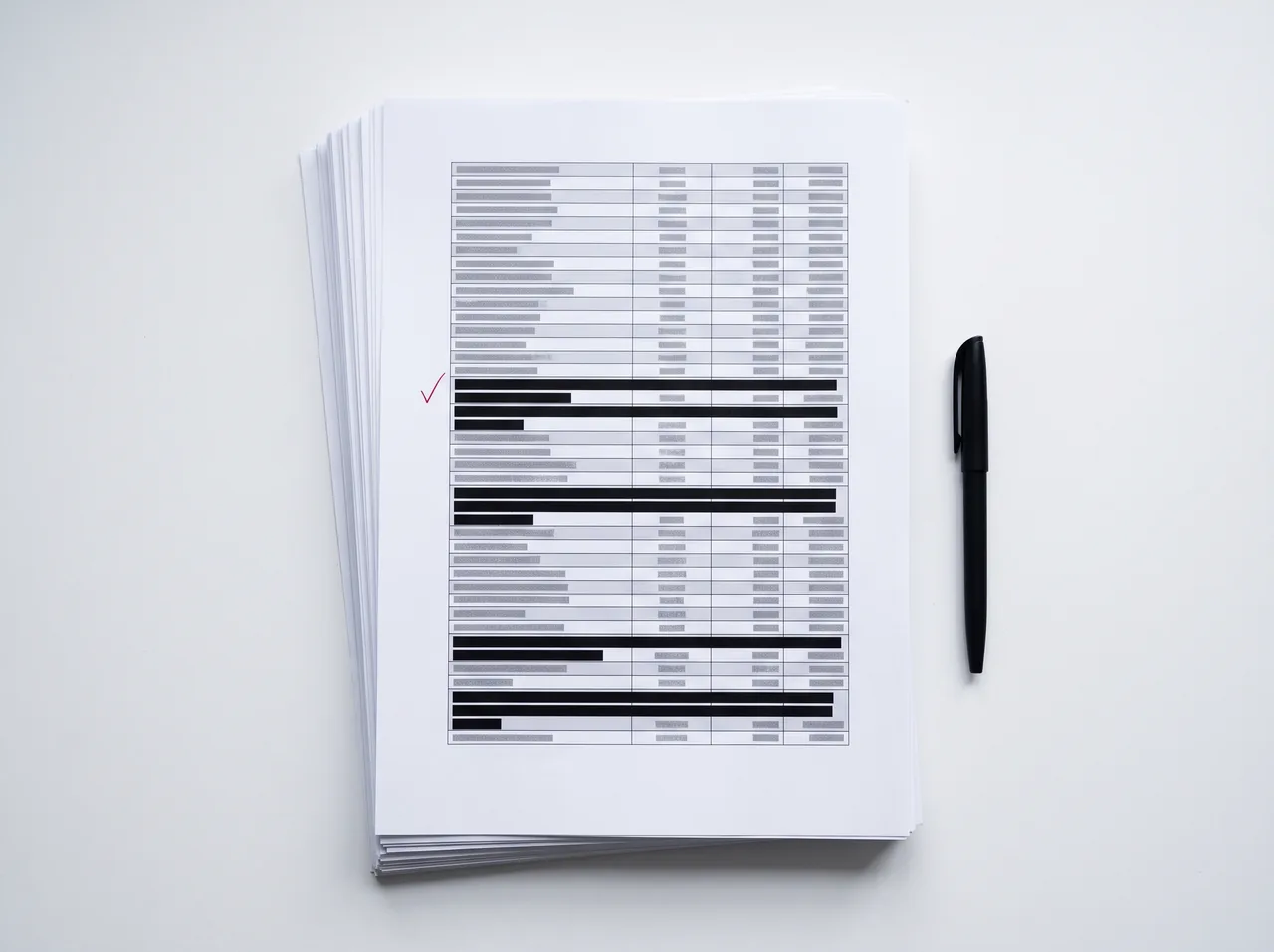 Printed DSAR disclosure pack with third-party data covered by black redaction bars and an approval mark