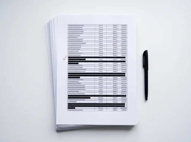 Printed DSAR disclosure pack with third-party data covered by black redaction bars and an approval mark